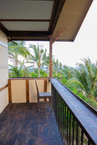 a chair sitting on the balcony of a house at Peaceful Hill Homestay in Ke Ga