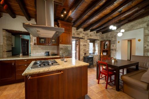 a kitchen with a stove and a table in a room at Casa Piedra, Hidden Gem, Jacuzzi, BBQ, Patio in Monagroulli in Monagrulli