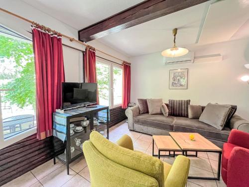 a living room with a couch and a tv at Holiday Home Sorgenfrei by Interhome in Frankenau