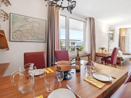 Un comedor con una mesa con una botella de vino. en Apartment Promenade - Utoring-73 by Interhome, en Arosa
