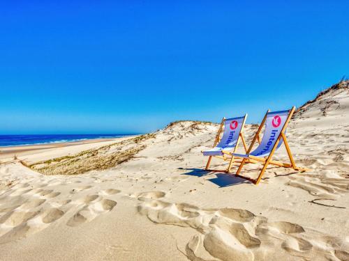 two chairs sitting in the sand on a beach at Apartment Les Océanides-14 by Interhome in Lacanau-Océan