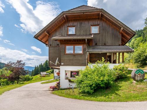 a wooden house with a gambrel roof at Apartment Herzele by Interhome in Arriach