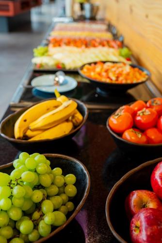 a buffet filled with bowls of fruit and vegetables at Ibis Budget Guarulhos Aeroporto in Guarulhos
