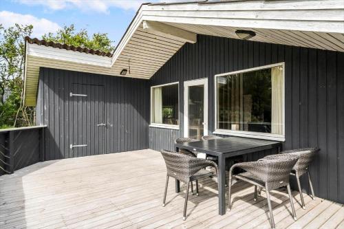 a patio with a table and chairs on a deck at 616-Hvide-Sande-Sigfred-Jensens-Vej-9 in Bjerregård