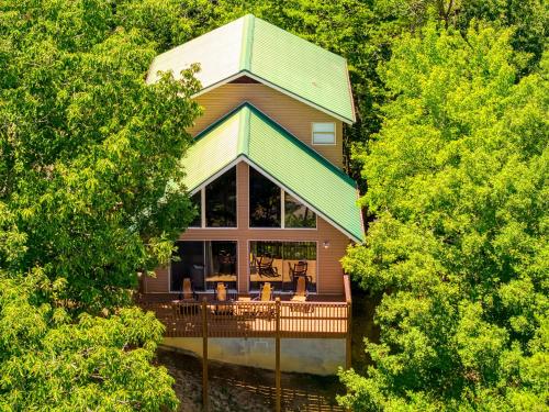 a house with a wrap around porch with trees at Heavenly Gaze in Pigeon Forge