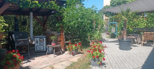 a garden with flowers in pots on a patio at Marianna Apartman in Gyenesdiás