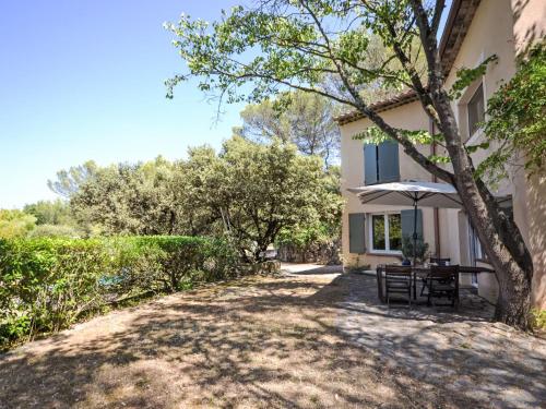 une table avec un parasol devant une maison dans l'établissement Apartment Kerkor by Interhome, à Braconnerie