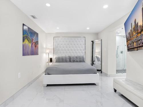 a white bedroom with a large bed in it at Luxury Villa with Heated Pool, Jaccuzzi, Gym, Games and More in Miami Gardens