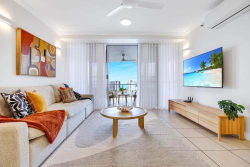 a living room with a couch and a table at Skyview Luxe at Marquis in Cairns