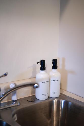 two bottles of soap sitting on top of a sink at Wilderness West Resort Cabin 5 in Colville