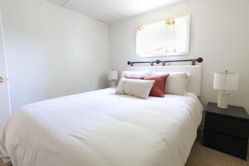 una camera da letto con un grande letto bianco con cuscini rossi di Wilderness West Resort Cabin 3 a Colville