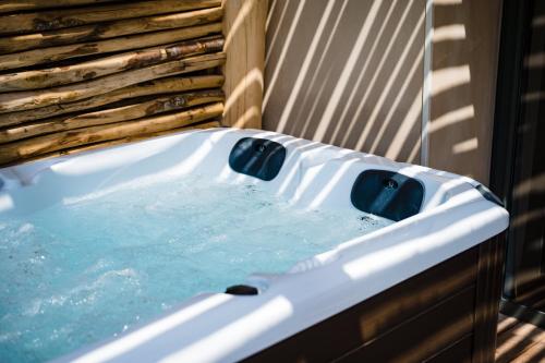 a bath tub with water in it next to a wall at Le Hameau Des Pesquiers Ecolodge & Spa, Curio Collection By Hilton in Hyères