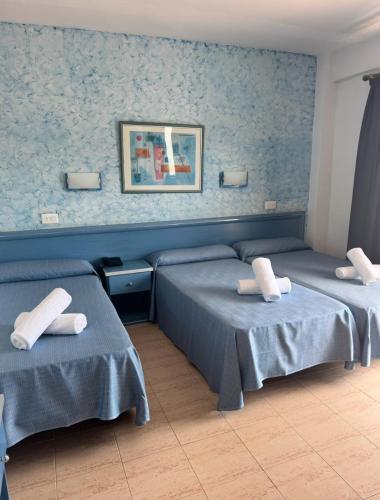 a room with two beds with towels on them at Santa Monica Playa in Salou