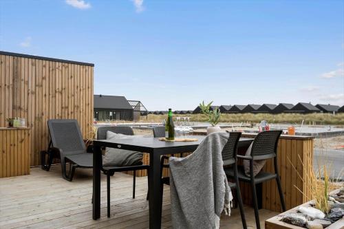 a patio with a table and chairs on a deck at 9953-Hvide-Sande-Langsand-212 in Hvide Sande