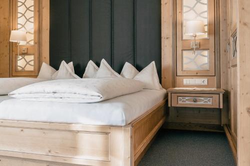 a bedroom with a large bed with white pillows at Residence by Gourmet & Wine Hotel Austria in Obergurgl