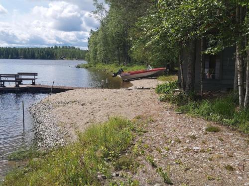 a boat is parked on the shore of a lake at Holiday Home Kokkoranta by Interhome in Ilomantsi