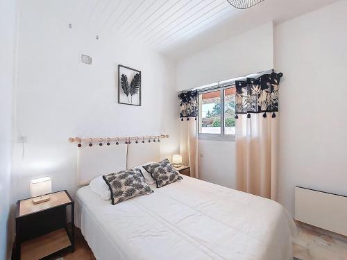 une chambre blanche avec un lit et une fenêtre dans l'établissement Holiday Home Mésanges by Interhome, à Saint-Palais-sur-Mer