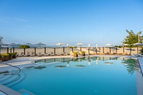 a pool at a hotel with chairs and umbrellas at Ile Hotel in Peschiera del Garda