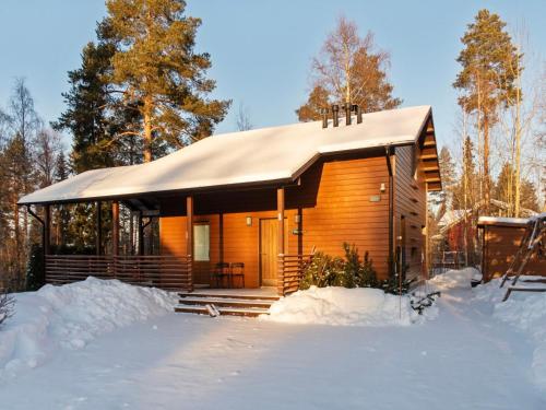 eine Blockhütte im Schnee im Wald in der Unterkunft Holiday Home Kanervarinne by Interhome in Vuokatti