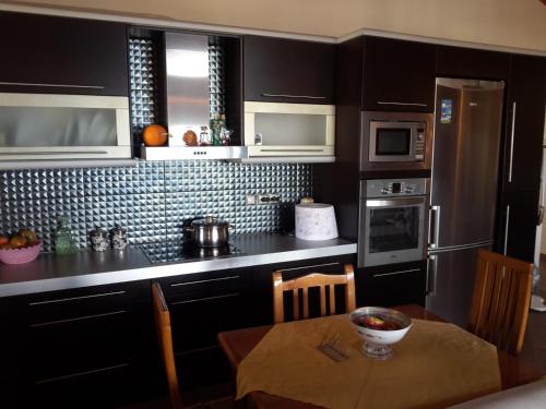 a kitchen with black cabinets and a table with a bowl on it at Apartment Rina in Sarandë