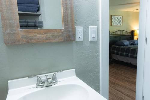 a bathroom with a sink and a mirror and a bed at Near Lake Texoma Quad-plex Kitchenette - 27 in Mead