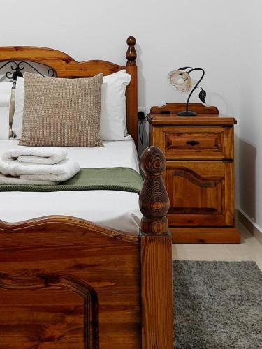a bedroom with a wooden bed with a lamp on a dresser at Valletta CityVibes in Il-Furjana