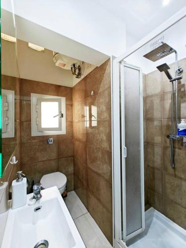 a bathroom with a toilet and a sink and a shower at Valletta CityVibes in Il-Furjana