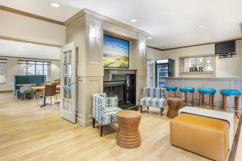 a lobby with a fireplace and a dining room at Clarion Pointe Sioux Falls Airport in Sioux Falls
