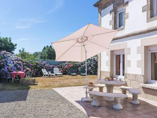 - une table de pique-nique avec un parasol dans la cour dans l'établissement Holiday Home Ty Mazud by Interhome, à Cléden-Cap-Sizun