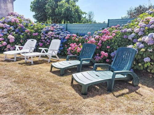 un groupe de chaises assises devant des fleurs dans l'établissement Holiday Home Ty Mazud by Interhome, à Cléden-Cap-Sizun