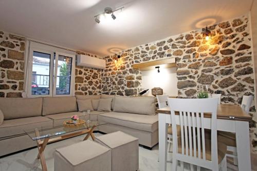 a living room with a couch and a table at Elysian Stone Apartment I in Litochoro