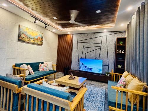 HawālbāghにあるThe Laylah - A Luxury Villaのソファと薄型テレビのあるリビングルーム