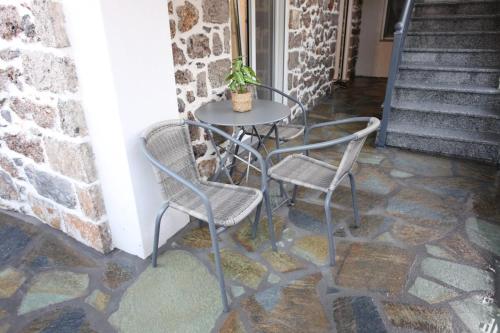 a table and two chairs on a patio at Elysian Stone Apartment I in Litochoro