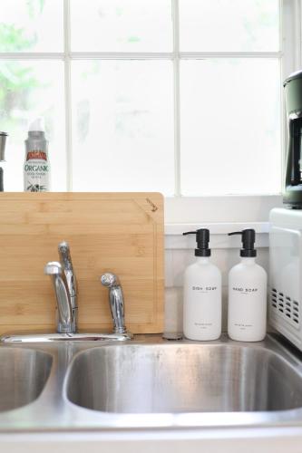 two bottles of detergent sitting on a kitchen sink at Wilderness West Resort Cabin 1 in Colville