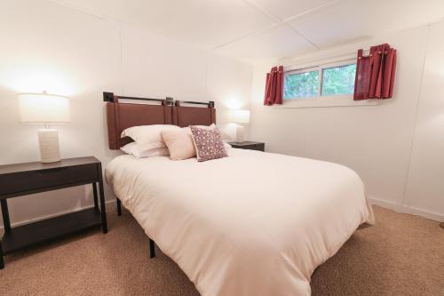 a white bedroom with a bed and a window at Wilderness West Resort Cabin 1 in Colville