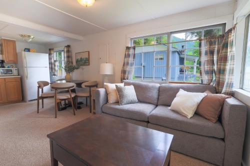 een woonkamer met een bank en een tafel bij Wilderness West Resort Cabin 1 in Colville