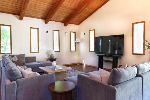 een woonkamer met banken en een flatscreen-tv bij Wilderness West Resort Cabin 1 in Colville