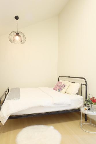 a white bedroom with a bed and a lamp at Villa at Waterville Khaoyai in Ban Khanong Phra Klang (1)