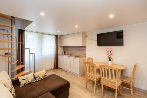 a small living room with a table and a kitchen at Pamario apartamentai in Nida