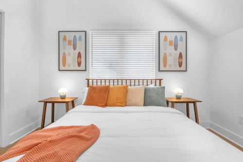 Un dormitorio con una cama grande con dos mesas. en Stylish 4BR Walk to the Beach, en Myrtle Beach