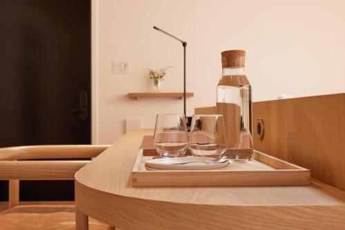 a wooden tray with glasses and a bottle on a table at Tranquil Waters at Dimensions - Cabin Two in Algonquin Highlands