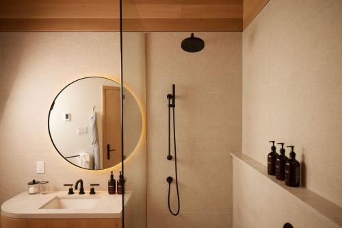 a bathroom with a shower and a sink and a mirror at Serenity by the Lake at Dimensions - Cabin Three in Algonquin Highlands