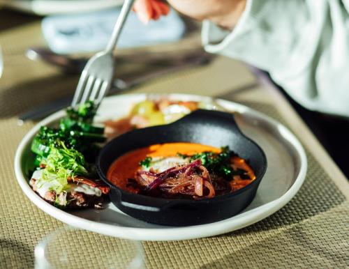 a plate of food with a bowl of soup and vegetables at Enchanted Eight at Dimensions - Cabin Eight in Algonquin Highlands