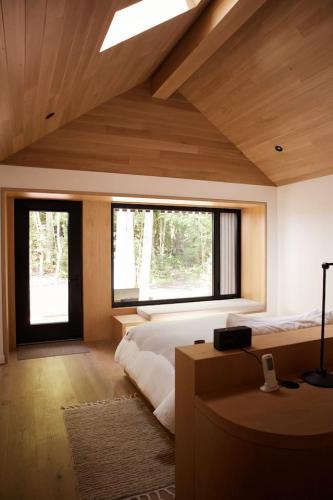 a bedroom with a large bed and two windows at Wildflower Rest at Dimensions - Cabin Fifteen in Algonquin Highlands