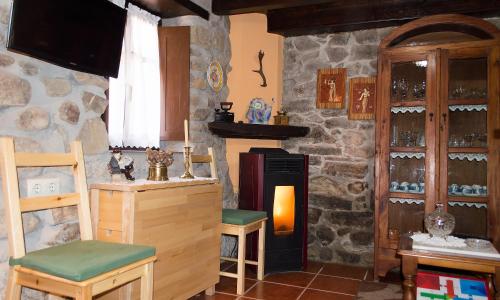 a room with a stove and a stone wall at La Ermita in Loroñe