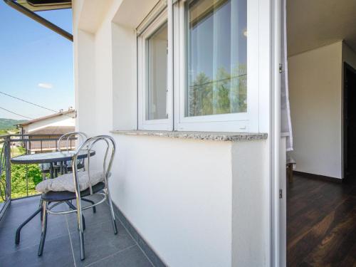 a balcony with a table and chairs and a window at Holiday Home Golub by Interhome in Duga Resa