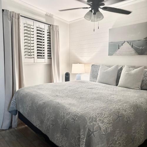 a bedroom with a bed with a ceiling fan at Coastal King at Seaside Villas Ocean View in Hilton Head Island