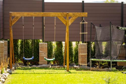 a swing set in a yard with a hammock at Bieszczadzka Hawira - w Centrum przy Jeziorze z Widokiem dla Rodzin in Polańczyk