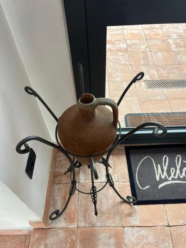 a pot sitting on a table in front of a door at Casa Ziranu Sa Domo e su Cantaru in Orani