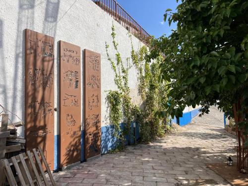 a wall with writing on it next to a sidewalk at Casa Ziranu Sa Domo e su Cantaru in Orani